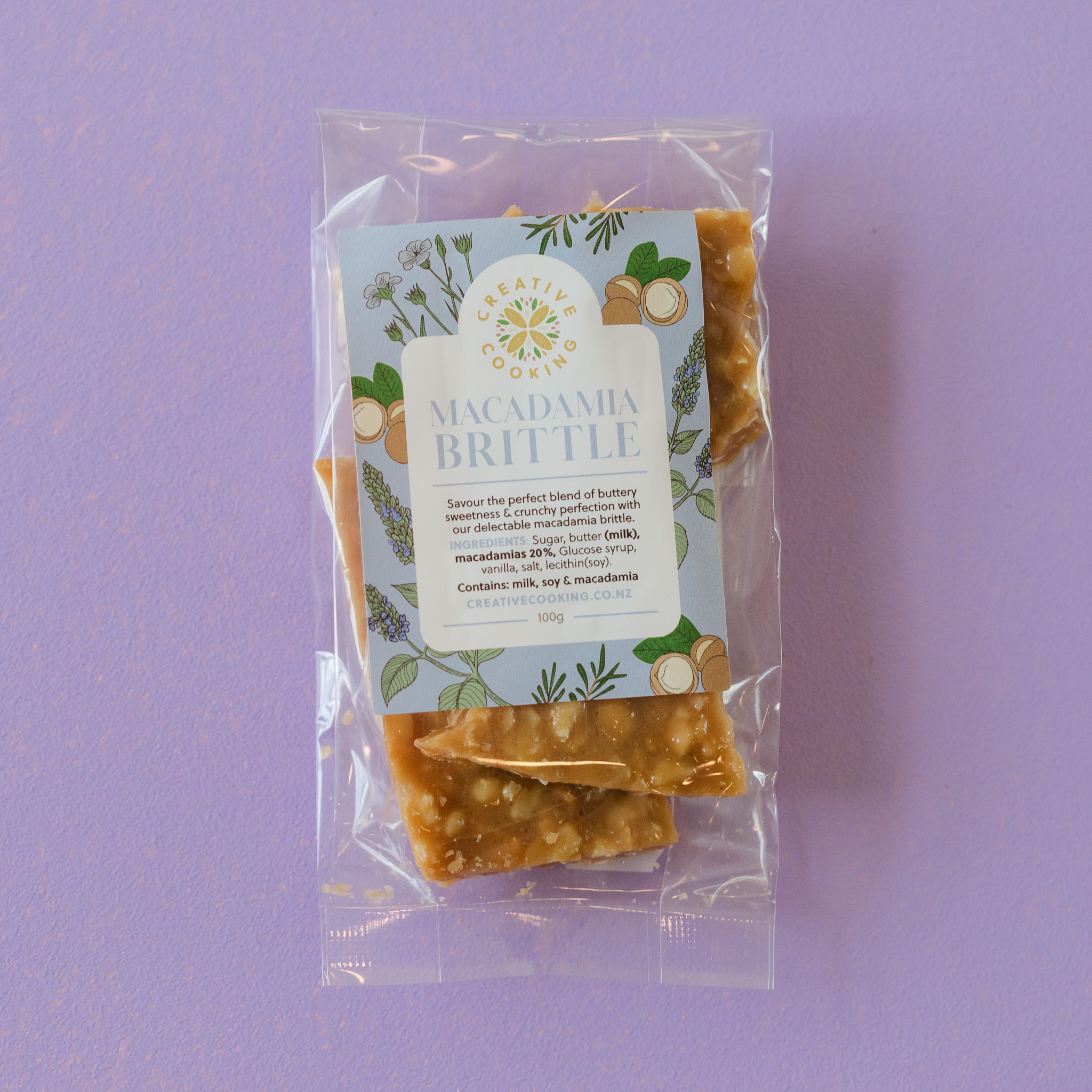 Macadamia Brittle by Superseed Crackers against purple background